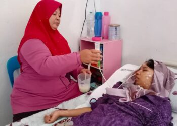 Latifah Abd. Razak, memberi susu kepada Nur Atiqah Noor Azma yang terlantar di Kampung Asam Jawa, Padang Pusing, Pendang, Kedah semalam.