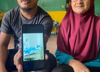MUHAMAD ZAFIFI Kamarulzaman (kiri) dan Wan Hayati Wan Yaakub (kanan) menunjukkan keadaan Kamarulzaman yang dikatakan tidak sedarkan diri di sebuab hospital di Korea Selatan. - UTUSAN/NORHAFIZAN ZULKIFLI