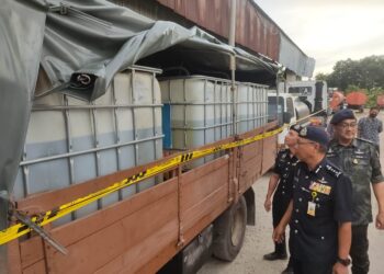 ARJUNAIDI Mohamed (depan) meninjau tong-tong mengandungi diesel bersubsidi yang diseleweng selepas bahan tersebut dirampas polis di sebuah gudang dekat Jalan Klang - Banting, Sungai Jenjarom, di Kuala Langat, Selangor.