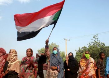 PESERTA protes mengibarkan bendera Sudan semasa berhimpun di Khartoum.AFP