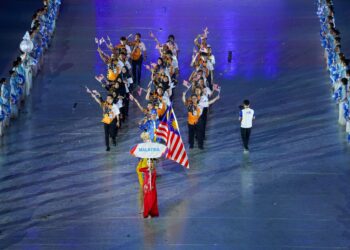 ATLET terjun negara, Nur Dhabitah Sabri membawa Jalur Gemilang ketika perarakan kontinjen Malaysia yang diketuai Chef-de-misson (CDM) ke Sukan SEA Hanoi 2021, Datuk Seri Nur Azmi Ahmad, pada Majlis Perasmian Sukan SEA 2021 di Stadium Nasional My Dinh, Hanoi, di sini hari ini. - UTUSAN/SHIDDIEQIIN ZON