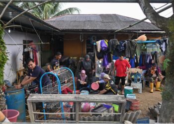 ANGGOTA sukarelawan membantu membersihkan barangan penduduk yang ditenggelami air di Kampung Durian Mentangau, Paka, Dungun, Terengganu, hari ini. - UTUSAN/PUQTRA HAIRRY ROSLI