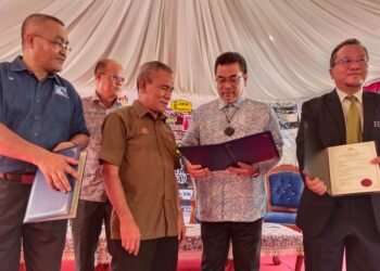 SULAIMAN Md. Ali (dua dari kanan) melihat dokumen penyerahan projek naik taraf sistem bekalan elektrik Hospital Melaka membabitkan pihak kontraktor, KKM dan JKR Melaka. - UTUSAN/MUHAMMAD SHAHIZAM TAZALI