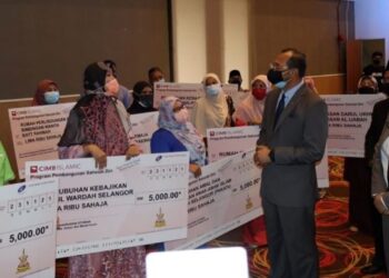 MOHD. Khairuddin Othman bermesra dengan salah seorang penerima sumbangan daripada Kerajaan Negeri Selangor dan MAIS di Dewan Jubli Perak Bangunan Sultan Salahuddin Abdul Aziz Shah, Shah Alam, hari ini. - FOTO/ABDUL RAZAK IDRIS