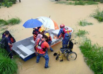 ANGGOTA Angkatan Pertahanan Awam membantu memindahkan mangsa banjir di Kampung Bata Gergaji, Jertih, Besut, hari ini.