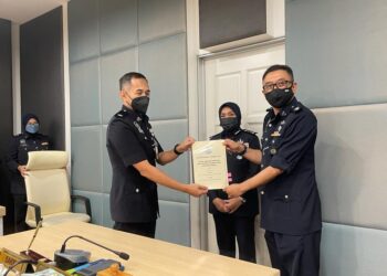 SURINA SAAD (tengah) menyaksikan upacara serah terima tugas antara Saifudin Aslin Abbas (kanan) sebagai Ketua Jabatan Siasatan dan Penguatkuasaan Trafik baharu di IPK Perlis, hari ini.- UTUSAN/NAZLINA NADZARI