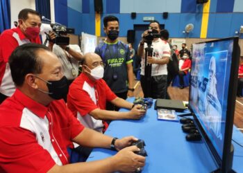 SHAFIEN Mamat (kanan) mencuba permainan e-Sport yang dipertandingkan dalam Kejohanan Karnival Sukan Piala Ketua Polis Negara di Kota Bharu, Kelantan, hari ini. - UTUSAN/ROSALWANI CHE SOH