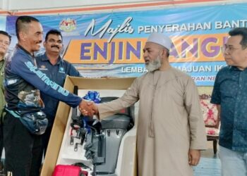 SYED Abu Hussin Hafiz Syed Abdul Fasal (dua dari kanan) menyerahkan bantuan enjin sangkut kepada nelayan di Matang, Bukit Gantang hari ini. - UTUSAN/WAT KAMAL ABAS