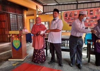 SYED Ibrahim Syed Ahmad menyampaikan sumbangan pelitup muka kepada Guru Besar Sekolah Agama Rakyat (SAR) Kelas al-Quran dan Fardu Ain (KAFA) Al Huda, Sungai Isap 2, Zarina Hashim (kiri) di SAR KAFA Al Huda, Sungai Isap 2, dekat Kuantan, Pahang.