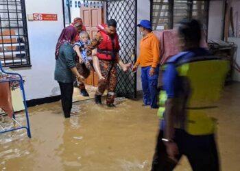 ANGGOTA bomba memindahkan penduduk yang terjejas banjir kilat di Taiping hari ini. - IHSAN JBPM PERAK