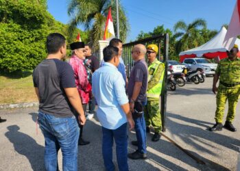 TAJUDDIN Abdul Rahman (dua dari kiri) dihalang oleh petugas keselamatan daripada memasuki pekarangan Dewan Besar Bandar Baru Felcra Seberang Perak, Pasir Salak hari ini. - UTUSAN