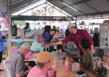 MOHD. RIDHWAN Mohd. Ali (kanan) bersalaman dengan orang ramai ketika menyantuni para pengundi di sekitar kawasan Parlimen Hang Tuah Jaya, Melaka. - UTUSAN/AMRAN MULUP