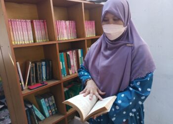 KHAIRIYAH Othman menunjukkan naskhah tafsir al-Quran yang masih elok dalam kebakaran bilik pusat sumber di SRAR Al Rahmanian di Kampung Datok, Tapah, Perak, hari ini. - UTUSAN