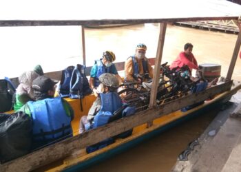 PENGUNJUNG Taman Negara menaiki bot untuk menyeberangi Sungai Tembeling ke jeti Kampung Kuala Tahan, semalam. - UTUSAN/HARIS FADILAH AHMAD