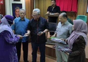 NOH Omar (tengah) menyerahkan sumbangan kepada bakal jemaah haji Parlimen Tanjong Karang di Kuala Selangor, Selangor, hari ini.