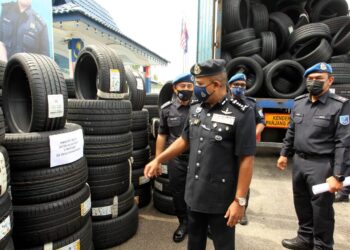 AYOB Khan Mydin Pitchay (tengah) melihat tayar  pelbagai saiz yang dirampas polis pada sidang akhbar di PPM Wilayah Dua Tampoi di Johor Bahru. - UTUSAN/BAZLAN IBRAHIM