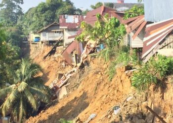 SEBANYAK 15 keluarga di Jalan Pohon Chelagi di Pasir Mas diarah mengosongkan rumah selepas tebing Sungai Kelantan runtuh awal pagi ini. - FOTO/YATIMIN ABDULLAH