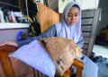 NUR FARYSYA ARYANY Faizul Azman menunjukkan dua pasang telekung yang menjadi pemberian terakhir arwah ibu dan bapanya sebelum mereka meninggal dunia dalam kemalangan di Kilometer 46, Kampung Selamat, Sungai Tong, Terengganu.