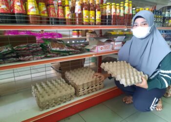 SEORANG pelanggan pasar raya menunjukkan rak dan bekas jualan telur ayam yang kosong di Kedah, semalam.
