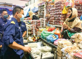 HAIRUL Effendy Adzmi (kiri) memeriksa premis seorang peniaga telur penyu di Pasar Payang 2 di Kuala Terengganu hari ini. - TENGKU DANISH BAHRI TENGKU YUSOFF