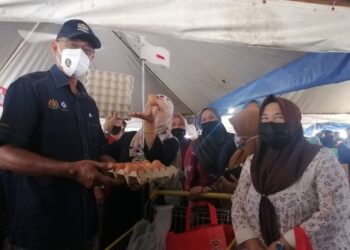 ROSOL Wahid memegang telur ayam dalam Program Jualan Keluarga Malaysia (PJKM) di Dataran Pasar Tani Kuala Ping di Hulu Terengganu hari ini. - NOOR HAYATI MAMAT