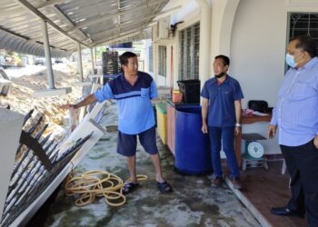CHEONG Kam Seng menunjukkan tembok pagar rumahnya yang runtuh dalam kejadian di Rumah Rakyat Sungai Layang, Rembau, petang semalam.-UTUSAN/NOR AINNA HAMZAH