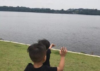 GAMBAR kenangan anak-anak seoang warga Malaysia, Mohd. Izwan melambai tangan  kepada bapa mereka yang berada di Singapura dari satu kawasan berhampiran Tambak Johor.