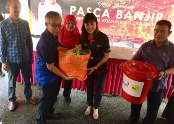 TEO Nie Ching (dua dari kanan) menyerahkan bantuan pasca banjir kepada salah seorang penerima di Taman Desa Tanjung Daman, Kuala Nerus, hari ini. - UTUSAN/TENGKU DANISH BAHRI TENGKU YUSOF