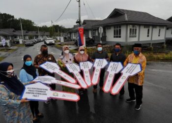 SEBAHAGIAN penduduk gembira menerima kunci rumah berlatar belakangkan kediaman baharu selepas Sesi Penyerahan Kunci Projek Perumahan Kampung Pendas Baru Fasa 2 di Pendas Laut, Iskandar Puteri di Johor. -UTUSAN/RAJA JAAFAR ALI