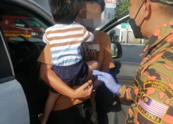 ANGGOTA bomba membuka pintu kereta yang berkunci dari dalam di sebuah stesen minyak di Behrang, Tanjung Malim, Perak, hari ini. - IHSAN JBPM PERAK