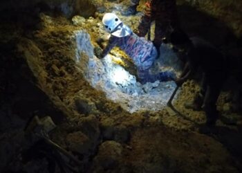 ANGGOTA bomba mengeluarkan mayat  Mohd. Zakaria Yahaya yang tertimbus ketika mendulang bijih di Batu Kurau, Taiping, Perak, semalam. - IHSAN JBPM
