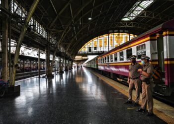 KONDUKTER bersiap sedia di platform stesen kereta api di Bangkok.-AFP