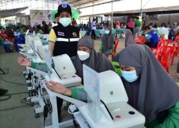 : PELAJAR Sekolah Islam Attarkiyah mengambil bacaan tekanan darah sebelum menerima suntikan vaksin Pfizer di Hospital Narathiwat.-AFP