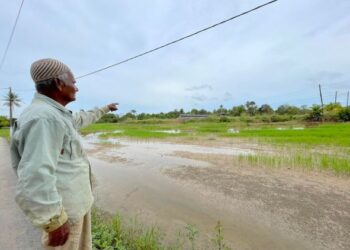 ALI Musa menunjukkan timbunan tiang elektrik konkrit yang tidak jauh dari rumahnya di Kampung Belukar, Changlun di Kubang Pasu. -UTUSAN/JAMLIAH ABDULLAH
