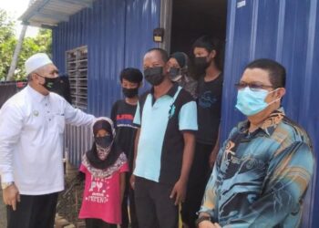 IMBAS.. Exco Perak  RAZMAN ZAKARIA (kiri) melawat lima sekeluarga yang tinggal dalam kabin kontena setelah rumah mereka terbakar di Semanggol dekat Bagan Serai