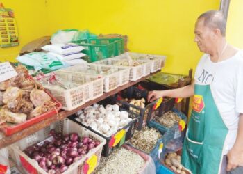 SUHAIMI Abd. Hamid menyusun beberapa barang kawalan sempena musim perayaan di gerainya di Masjid Tanah, Melaka. - UTUSAN/MUHAMMAD SHAHIZAM TAZALI