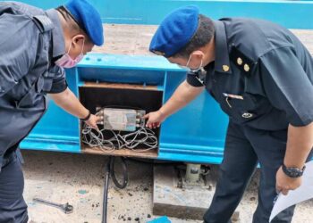 PEGAWAI penguatkuasa KPDNHEP Perak memeriksa mesin penimbang sawit yang di Manjung, Perak, hari ini. - UTUSAN