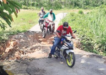 PENDUDUK terpaksa menolak motosikal ketika melalui titi konkrit yang mendap di Lorong Bukit Pinang, Kampung Barokas, Kuala Nerang, Padang Terap, Kedah. - UTUSAN/MOHD. RIFAAT ABD. HAMID