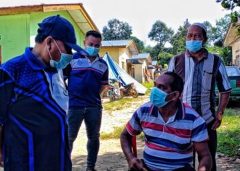 MUSTAPA Long (berdiri, kiri) sedang beramah mesra dengan Batin Harun Abdullah (duduk) selepas disuntik vaksin di Kampung Bencah Kelubi, Telok Gunung, Lipis baru-baru ini. - HARIS FADILAH AHMAD   