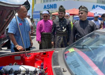 MD. Anizam Abdul Rahman (kanan) melihat kreativiti pemilik kereta klasik dalam penjagaan enjin kenderaan lama pada Pelancaran Bulan Kesenian dan Kebudayaan Peringkat Parlimen Pasir Puteh, Kelantan, hari ini. - UTUSAN/TOREK SULONG