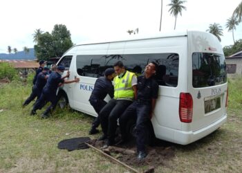 SEBAHAGIAN anggota polis terpaksa menolak van dinaiki mereka yang tersangkut akibat mendapan tanah ketika menyertai program pemberian bantuan kepada penduduk setempat di Pulau Pinang.