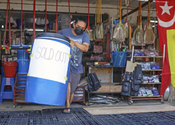 Pekerja sebuah kedai perkakasan meletakkan notis kehabisan tong air di Jalan Kebun, Shah Alam, Selangor, semalam. Gangguan bekalan air di Shah Alam dijadual berlaku esok. – UTUSAN/ZULFADHLI ZAKI