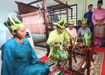 AHMAD ZAHID Hamidi (dua dari kiri) mencuba alat penenun, sambil diperhatikan oleh Menteri Besar, Datuk Seri Wan Rosdy Wan Ismail (tiga dari kiri) ketika melawat Pusat Tenunan Diraja, di Pos Betau, Kuala Lipis di Lipis, Pahang. - FOTO/SHAIKH AHMAD RAZIF