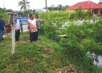 PENDUDUK menunjukkan keadaan parit yang dipenuhi tumbuhan dan tidak lagi mampu menampung limpahan air jika hujan lebih dua hari, di Taman Dato’ Hormat, Teluk Panglima Garang, di Kuala Langat, Selangor. - UTUSAN / ABDUL RAZAK IDRIS