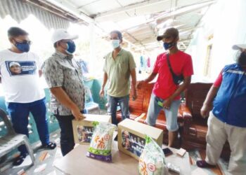 ABDUL Halim Ghani (tengah) bersama Mohd. Norizan Jusoh (dua kanan) ketika menerima kunjungan Rasman Ithnain (dua dari kiri) untuk menyerahkan sumbangan wang tunai dan barangan keperluan harian kepada kedua-dua nelayan itu di Tanjung Sedili, Kota Tinggi, Johor. 