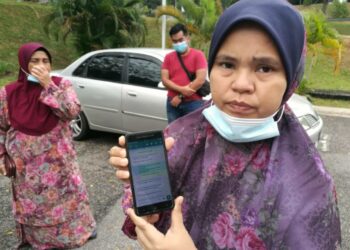 SITI Ida Aminah Abdul Mahat menunjukkan mesej yang dihantar Muhamad Hafiz Abd. Kadir @ Roslan di pekarangan Unit Forensik, Hospital Tampin, Tampin, Negeri Sembilan, hari ini.