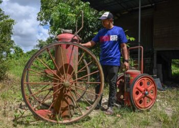 AZLAN Alias menunjukkan alat pemadam api yang dipercayai dikeluarkan di Jepun sekitar tahun 60-an di Kampung Teluk Pasu, Kuala Terengganu. - UTUSAN/PUQTRA HAIRRY ROSLI