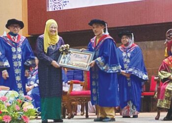 AILIN Ton mewakili arwah suaminya, Dr. Wan Abdul Rahman menerima Anugerah Jasa Bakti yang disampaikan oleh Nik Muhammad Nasri Nik Malek pada Majlis Konvokesyen ke-22 UCTATI, Kemaman, Terengganu, semalam. – FOTO/NIK NUR IZZATUL HAZWANI NIK ADNAN