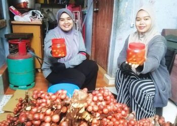 NUR Fatin Ayunie Mohammad (kanan) dan Nur Fatin Fitri menunjukkan jeruk dihasilkan di rumah mereka di Perumahan Bukit Che Nik, Binjai Rendah, Marang, Terengganu. – FOTO/NOOR HAYATI MAMAT