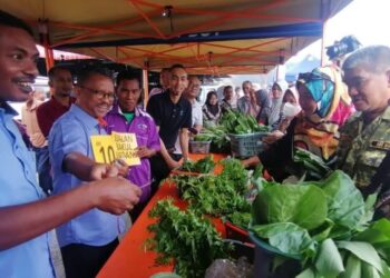 NUKMAN Hashim (kiri) membuat jualan khas kombo sayur-sayuran @Bakul Madani sempena Program Jualan Khas Syawal Madani di Pasar Tani Kuala Berang di Hulu Terengganu, hari ini. - FOTO/NOOR HAYATI MAMAT